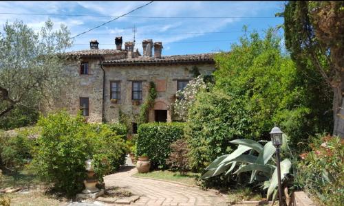 Una vieja casa de piedra con dos chimeneas encima. en B&B Il Casale Del Ginepro, en Migliano
