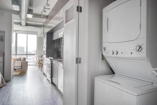a white kitchen with a washer and dryer in it at NoMa studio w gym pet grooming nr metro WDC-701 in Washington