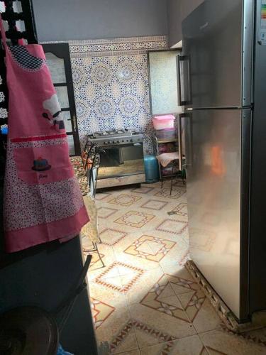 a kitchen with a refrigerator and a tile floor at Studio en face de la plage in Temara