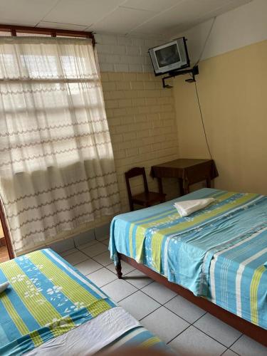 Alojamiento Grau في تارابوتو: غرفة نوم بسريرين وتلفزيون على الحائط
