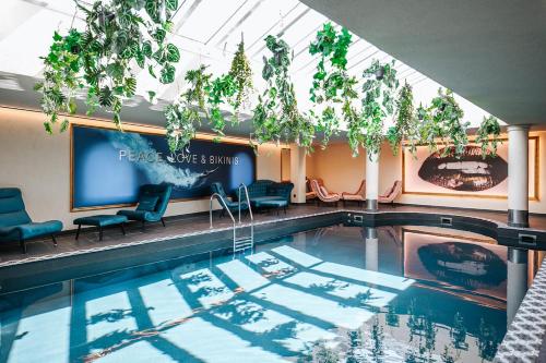 einen Pool in einem Hotel mit Stühlen und einem Bildschirm in der Unterkunft Wellness Aparthotel "Lechlife" incl Infinity Pool - 400m zum Lift in Reutte