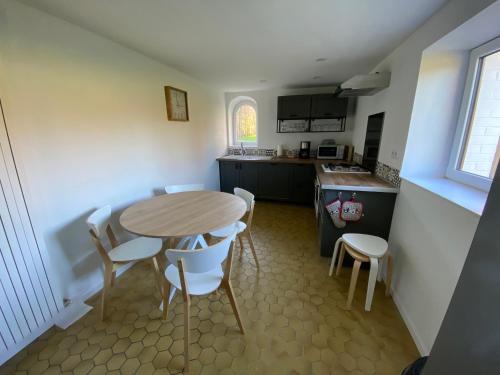 a kitchen with a table and chairs in a room at Maison de campagne moderne in Beaurieux