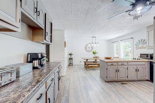 a kitchen with white cabinets and a table in it at The Haggai House in Demorest