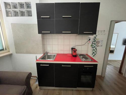 una cucina con lavandino e piano di lavoro rosso di Affittacamere La Filigrana (Ospedale) a Fabriano