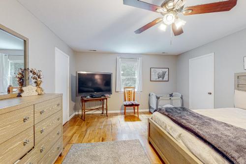 a bedroom with a ceiling fan and a television at The Haggai House in Demorest