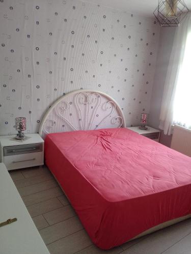 1 dormitorio con 1 cama grande de color rojo y 2 mesas en Mete konaklari en Rize