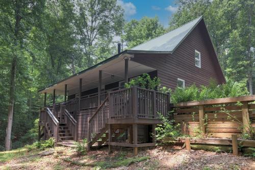 a cabin in the woods with a large deck at The Haggai House in Demorest