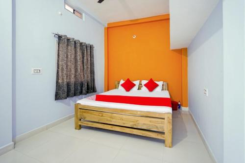 1 dormitorio con 1 cama con pared de color naranja en Flagship Youngsky, en Gulzārbāgh