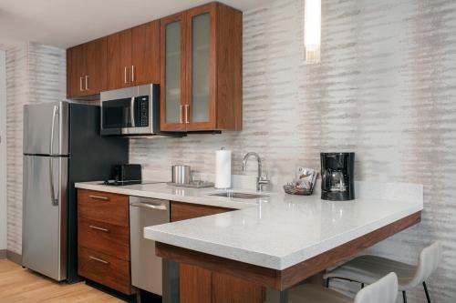 a kitchen with a sink and a refrigerator at Residence Inn by Marriott Norwalk in Norwalk
