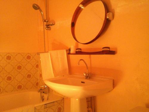 uma casa de banho com um lavatório, um espelho e uma banheira em La Colombière em Chasnais