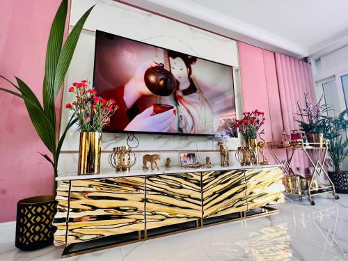 a dresser with a tv on a pink wall at Tropical Villa in Adeje