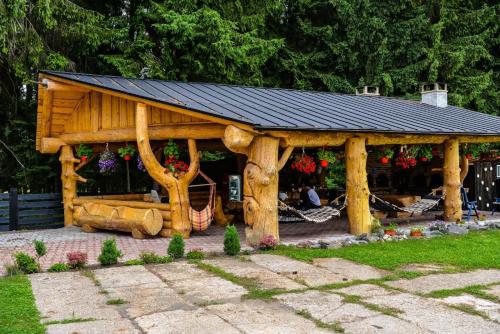 a wooden gazebo with a bench in a yard at Pensiunea Agroturistică Magdalina in Vatra Dornei