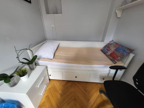 a small bed in a small room with a desk at Zabytkowa Kamienica in Gdańsk