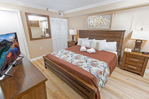 1 dormitorio con 1 cama grande y TV en 14Th Floor Condo with Amazing Views, en Myrtle Beach
