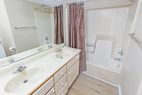 y baño con 2 lavabos, bañera y ducha. en 14Th Floor Condo with Amazing Views, en Myrtle Beach