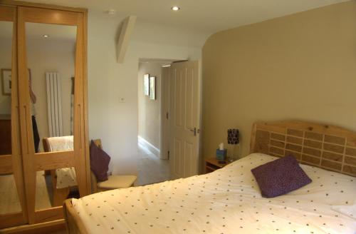 1 dormitorio con 1 cama grande y espejo en The Cwtch en Haverfordwest