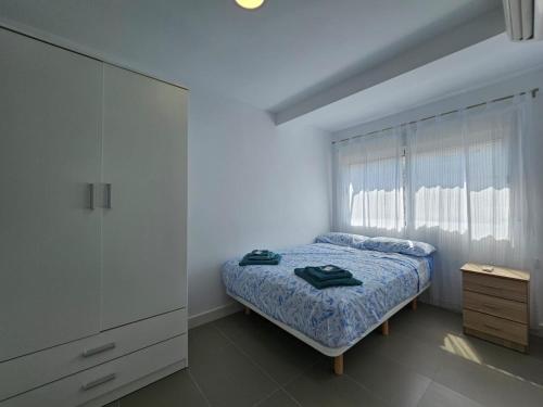 Apartamento a pie de playa I في فارو دي كوييرا: غرفة نوم بسرير وخزانة ونافذة