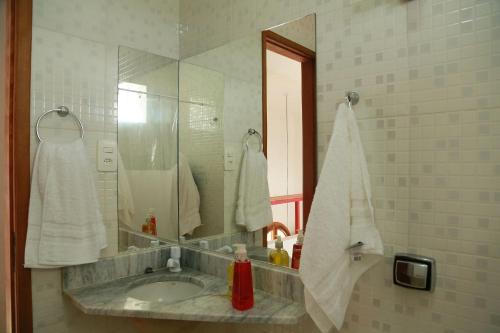 ein Badezimmer mit Waschbecken und Spiegel in der Unterkunft Conforto e bom gosto no Recôncavo da Bahia. in São Félix