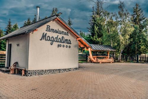 a building with a sign on the side of it at Pensiunea Agroturistică Magdalina in Vatra Dornei