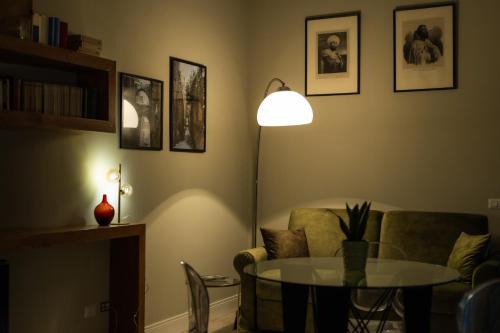a living room with a table and a lamp at Palazzo Murat Luxury Rooms in Arienzo San Felice