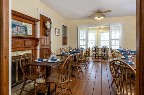 a dining room with tables and chairs and a fireplace at Old Stagecoach Inn in Waterbury