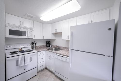 cocina blanca con electrodomésticos blancos y nevera en 138 Fully Furnished, amenities galore, en Scottsdale