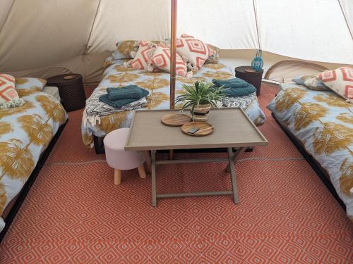 una habitación con 2 camas y una mesa en una tienda de campaña en Belle tent 2 en Wrexham