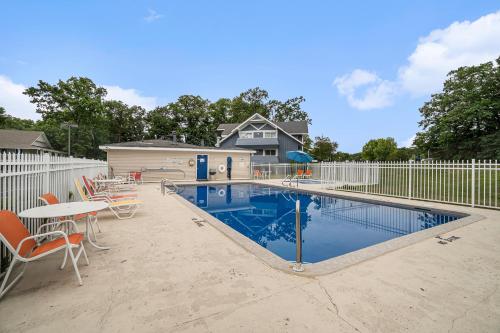 a swimming pool with chairs and a white fence at Travelodge by Wyndham Traverse City MI in Traverse City