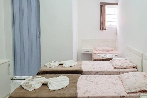 3 posti letto in una stanza con asciugamani di Pousada dos Anjos Sao Miguel Arcanjo a São Miguel Arcanjo