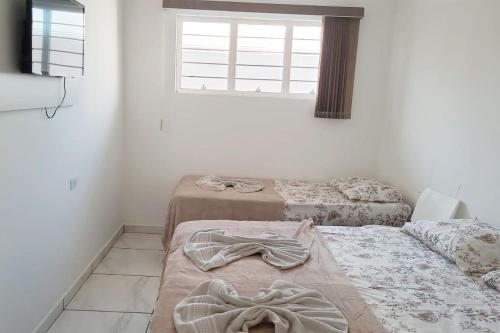 um quarto com duas camas e uma janela em Pousada dos Anjos Sao Miguel Arcanjo em São Miguel Arcanjo