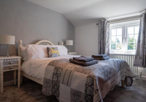 um quarto com uma cama e uma janela em Flint Cottage em Debenham