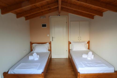 2 letti in una camera con lenzuola e cuscini bianchi di Phoenix Villa - Comfort living in Nafplio ad Ária