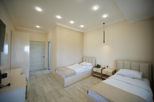 Habitación de hotel con 2 camas y baño en WHITE HOTEL GYUMRI en Gyumri