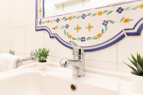een badkamer met een wastafel met een bloemenpatroon op de muur bij [Firenze Duomo 400 metri] *Dimora degli specchi* in Florence
