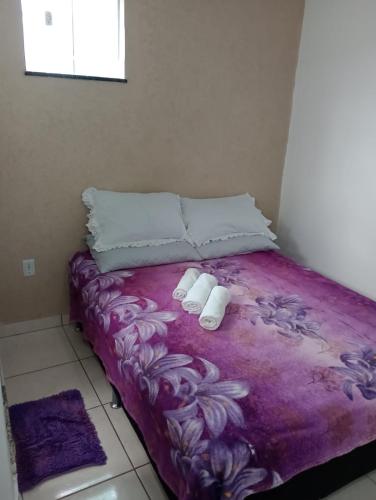 a bed with two pillows and two towels on it at Hospedagem Por do sol in Arraial do Cabo