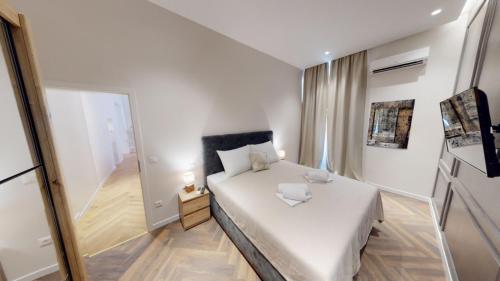 a small bedroom with a white bed and a mirror at MATE in Rijeka