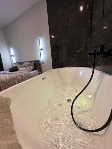 La salle de bains est pourvue d'une baignoire remplie d'eau. dans l'établissement Gîte Liberta - Equipé d'une balneo entre Dinan et St Malo, à Saint-Pierre-de-Plesguen