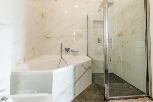 La salle de bains est pourvue d'une douche, d'une baignoire et d'un lavabo. dans l'établissement Villa Daniel, à Menton