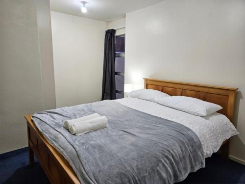 una camera da letto con un grande letto con due asciugamani di 4 Bedrooms, VERY Central Townhouse! a Wellington