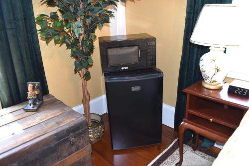 a microwave sitting on top of a black refrigerator at Silsbee's by Daniels House in Salem