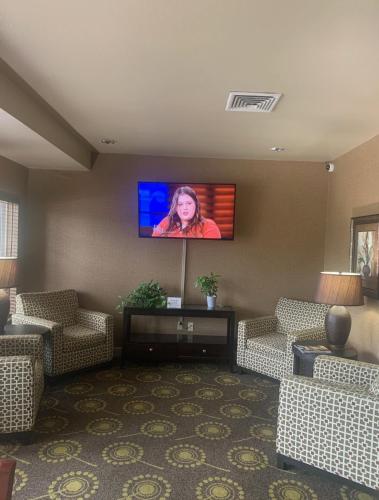 a living room with a flat screen tv on a wall at MainStay Suites St Robert - Fort Leonard Wood in Saint Robert