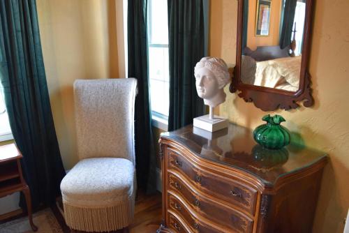 a dresser with a bust and a chair and a mirror at Silsbee's by Daniels House in Salem