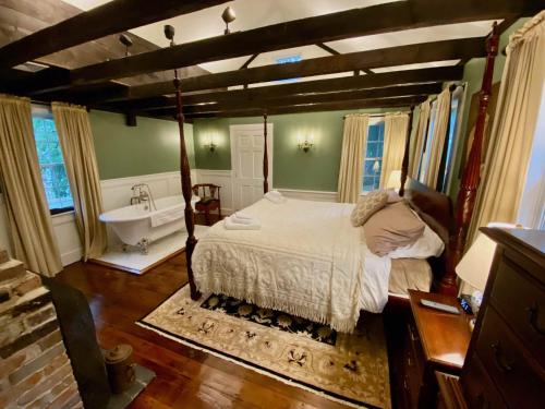 a bedroom with a bed and a tub and a sink at Silsbee's by Daniels House in Salem