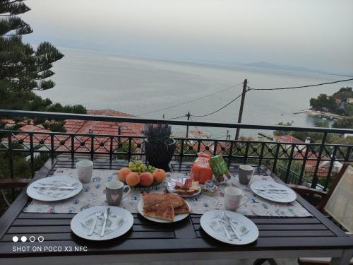 a table with plates of food on top of a balcony at MESONISI maisonette in Afissos