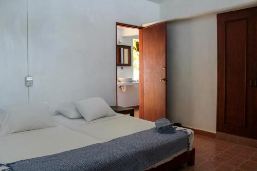 a small bedroom with a bed and a mirror at Casa Azul in San Agustinillo