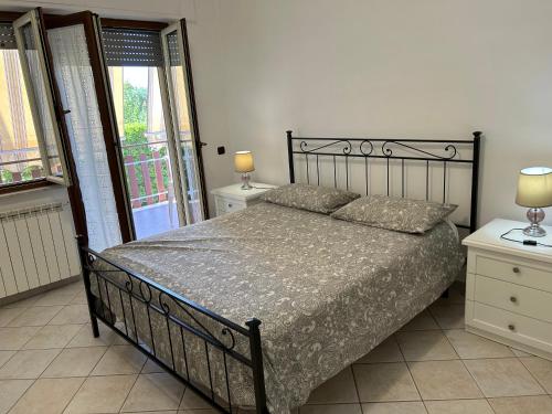 - une chambre avec un lit, deux lampes et une fenêtre dans l'établissement Leda House, à Villaggio del Fanciullo