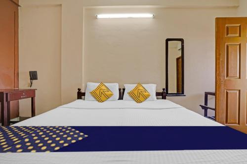 um quarto com uma cama com almofadas amarelas e azuis em SPOT ON Bright Homes em Elūr