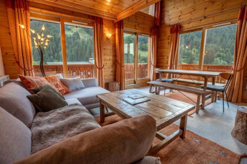 una sala de estar con un sofá y una mesa en Grand Duc 8, en Méribel