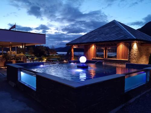 a pool in front of a building at night at Bremanger Fjord Hotell in Svelgen