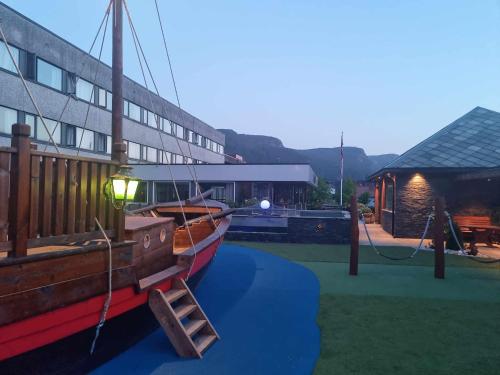 a boat is parked in front of a building at Bremanger Fjord Hotell in Svelgen